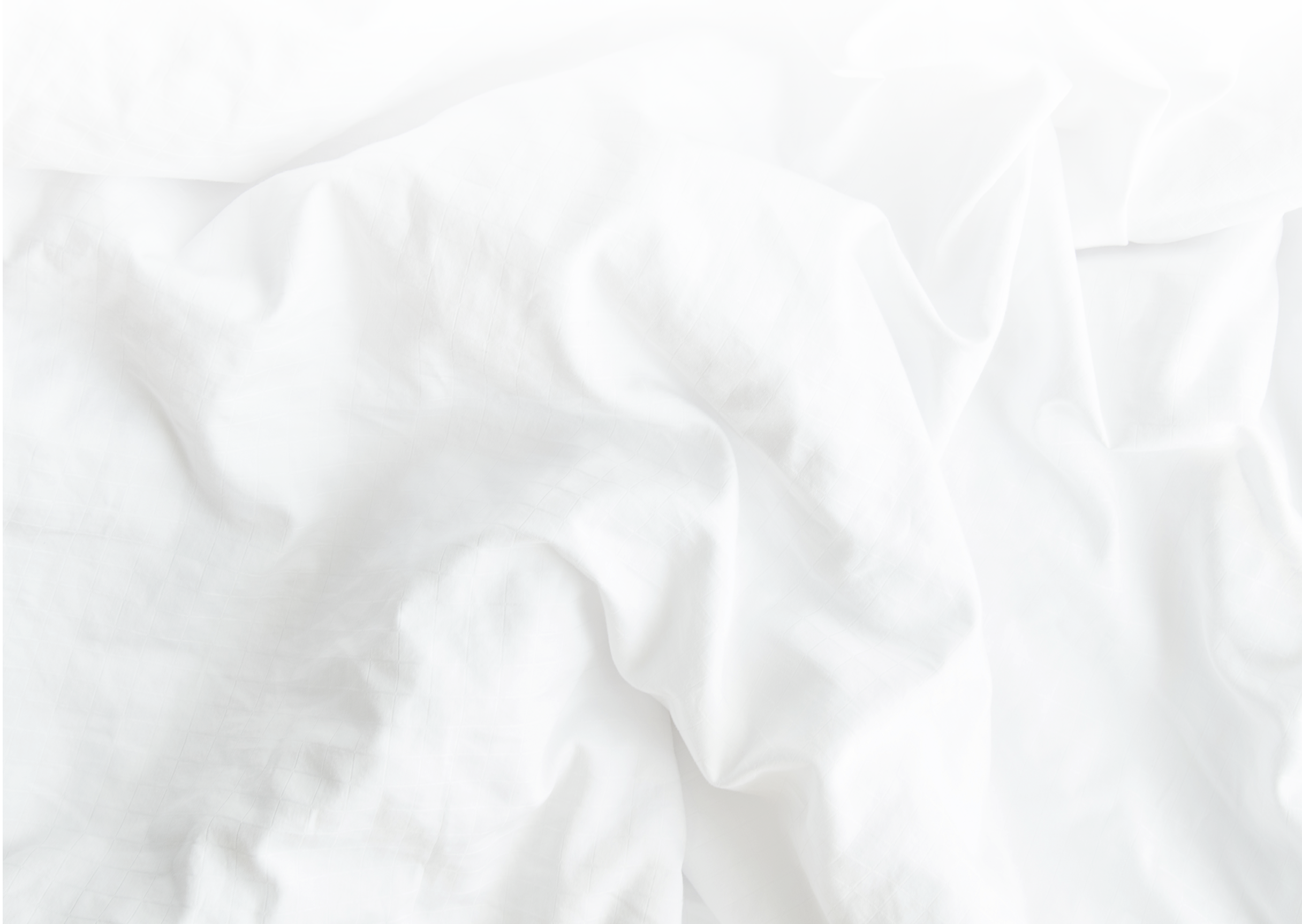 White wrinkled fabic texture,Close up unmade bed sheet in the bedroom after night sleep Soft focus.