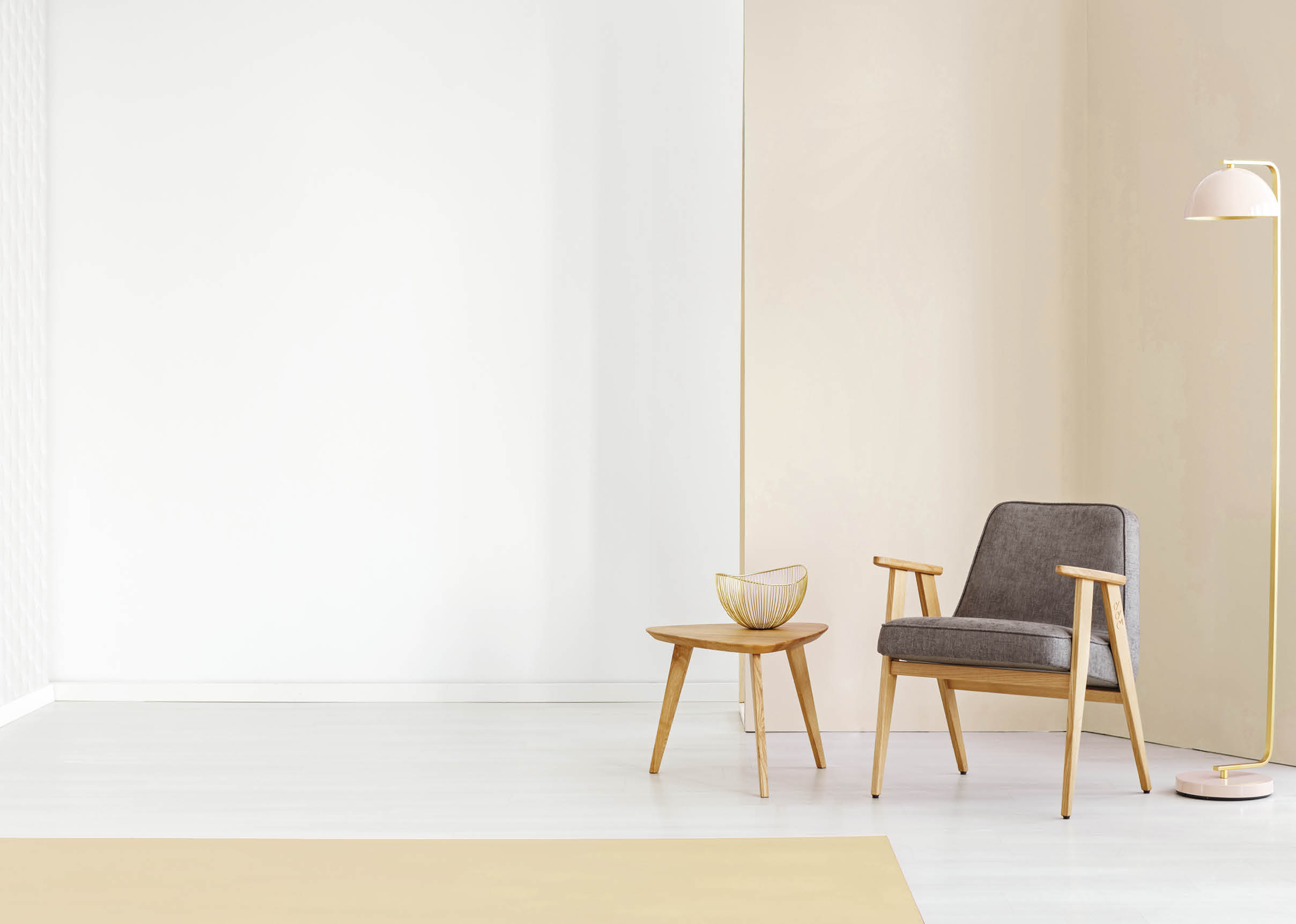 Lamp and grey armchair next to a wooden table in simple living room interior with copy space